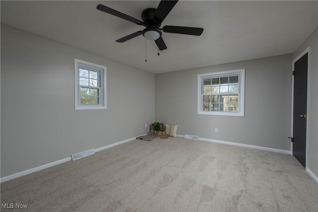 carpeted spare room featuring ceiling fan