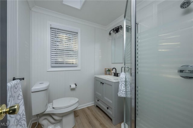 bathroom featuring an enclosed shower, ornamental molding, vanity, wood-type flooring, and toilet