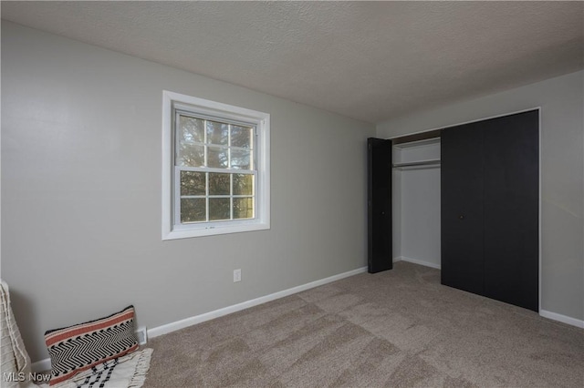 unfurnished bedroom featuring light carpet and a textured ceiling