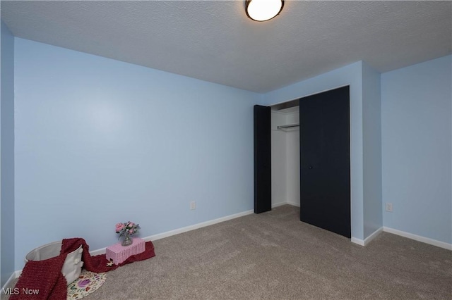 unfurnished bedroom with a closet, carpet floors, and a textured ceiling