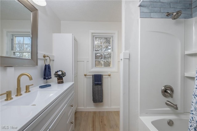 bathroom featuring shower / bath combo with shower curtain, vanity, hardwood / wood-style floors, and a textured ceiling