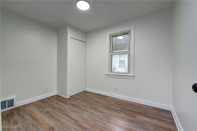 unfurnished room with hardwood / wood-style flooring