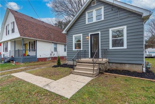 bungalow featuring covered porch and a front yard