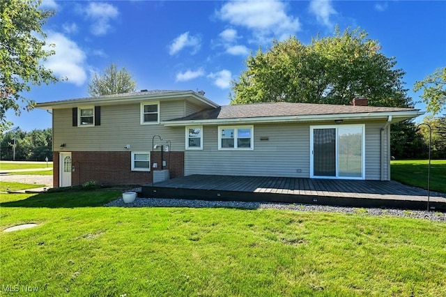 rear view of property featuring a yard and a deck