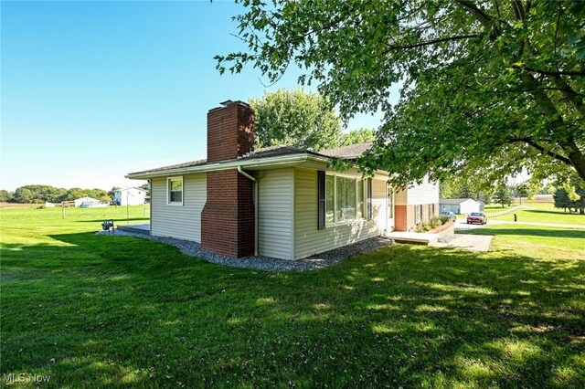 view of side of home with a lawn