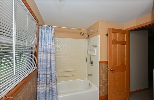 bathroom with shower / tub combo and tile walls