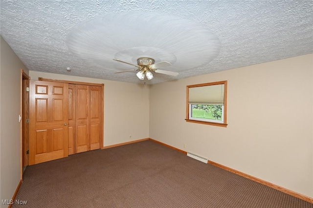 unfurnished bedroom with ceiling fan, a closet, dark carpet, and a textured ceiling