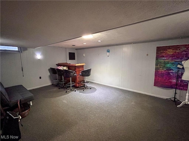 carpeted dining room featuring bar and a textured ceiling