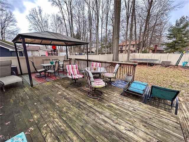 wooden deck featuring a gazebo and a trampoline