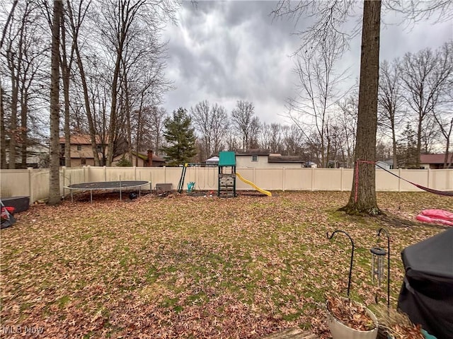 view of yard featuring a playground and a trampoline