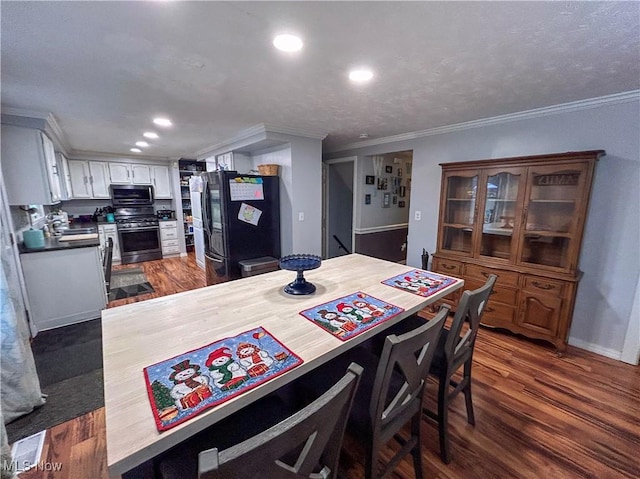 dining area featuring dark hardwood / wood-style flooring, crown molding, and a textured ceiling