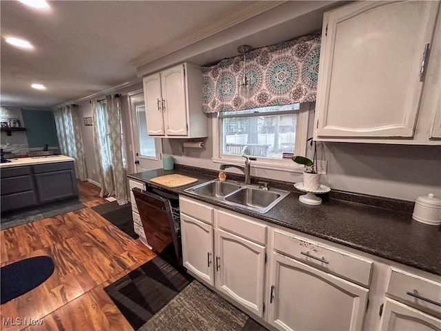 kitchen featuring dark hardwood / wood-style flooring, dishwasher, sink, and white cabinets