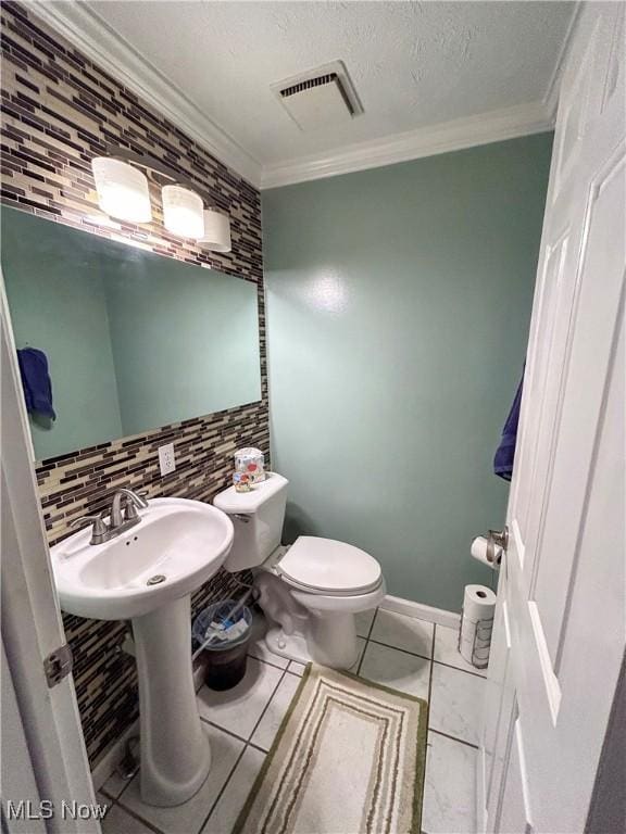 bathroom with tile patterned floors, ornamental molding, toilet, and decorative backsplash