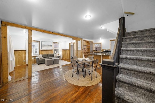 dining room with wood walls and wood-type flooring