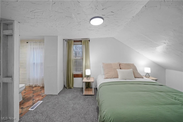 carpeted bedroom with lofted ceiling and a textured ceiling