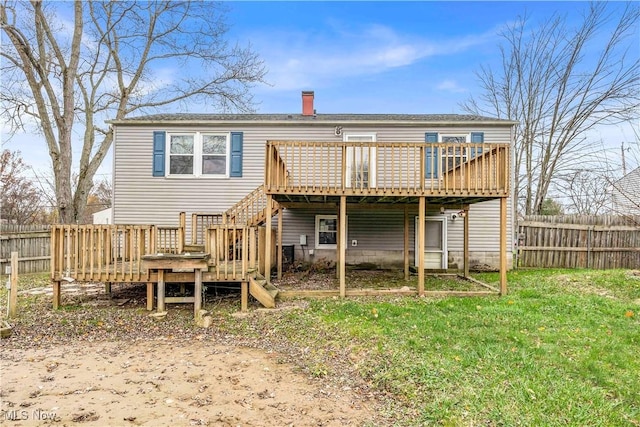 rear view of property featuring a lawn and a deck