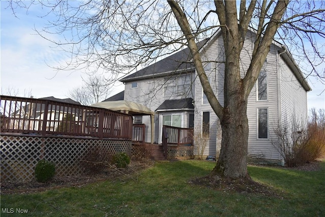 rear view of house with a lawn and a deck