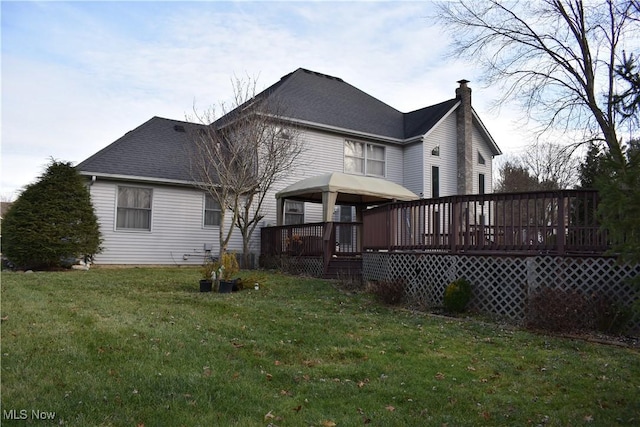 rear view of property with a lawn and a deck