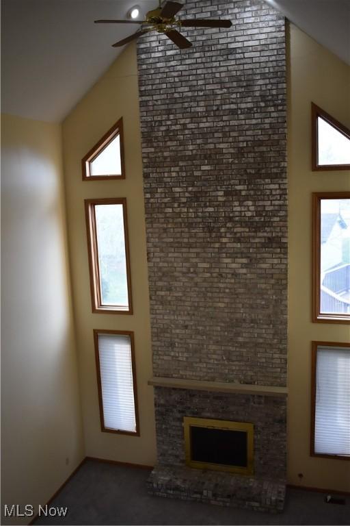 unfurnished living room featuring ceiling fan and vaulted ceiling