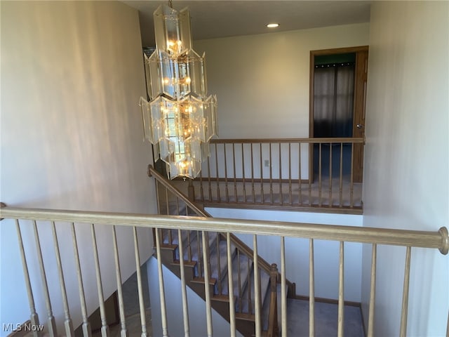 staircase featuring an inviting chandelier