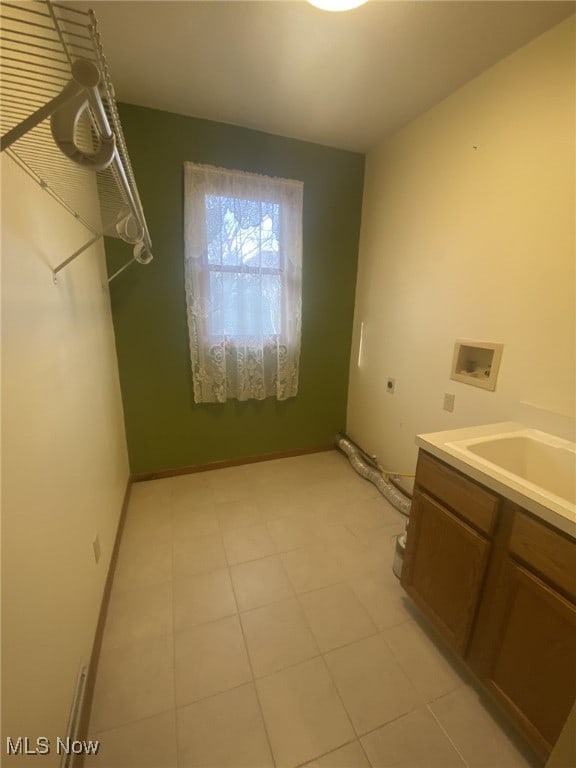 laundry room featuring sink, cabinets, electric dryer hookup, hookup for a washing machine, and light tile patterned floors