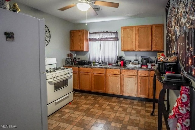 kitchen with white appliances, ceiling fan, and sink