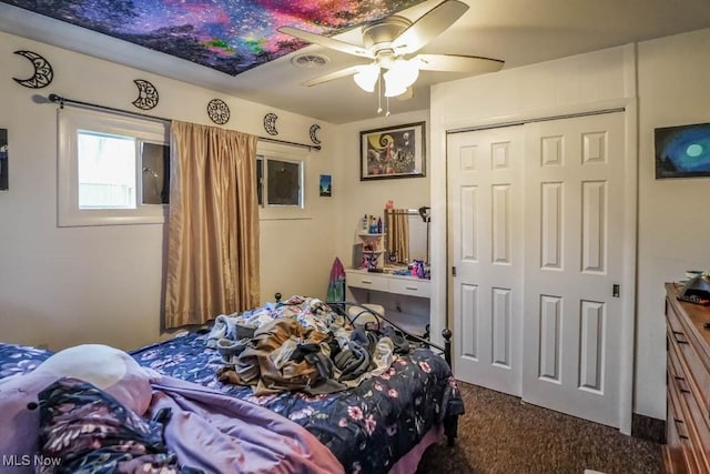 bedroom featuring dark colored carpet, a closet, and ceiling fan