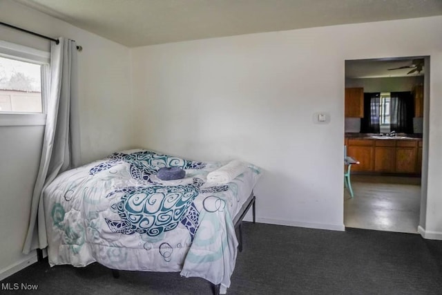 bedroom featuring dark colored carpet and sink