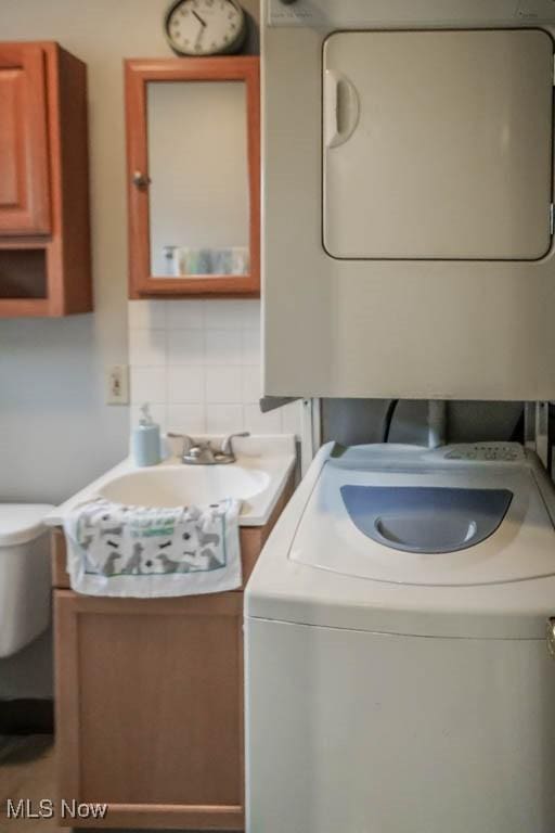 laundry room with stacked washer / drying machine