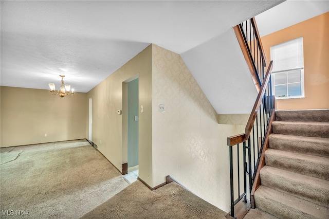 staircase featuring carpet flooring, lofted ceiling, and a notable chandelier