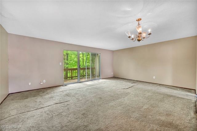 unfurnished room featuring a notable chandelier and carpet floors