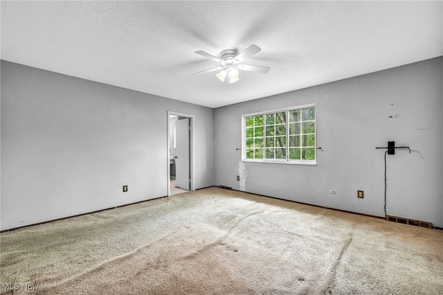 carpeted empty room featuring a textured ceiling and ceiling fan