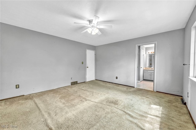 unfurnished bedroom with connected bathroom, ceiling fan, and light carpet