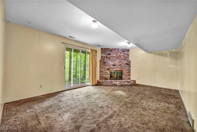 unfurnished living room featuring carpet flooring, a fireplace, and a textured ceiling