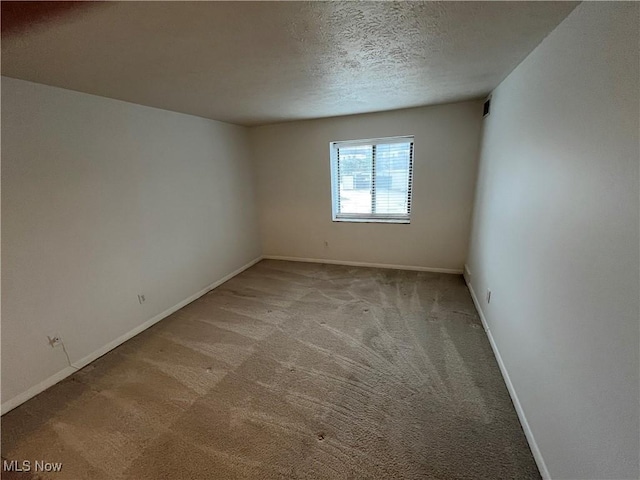 carpeted spare room featuring a textured ceiling