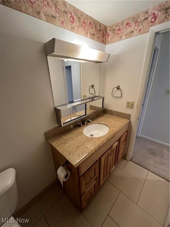 bathroom featuring tile patterned floors, vanity, and toilet