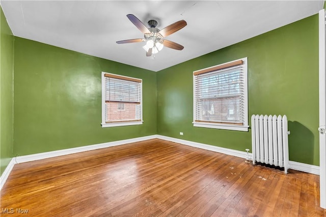 unfurnished room featuring radiator, ceiling fan, and wood-type flooring