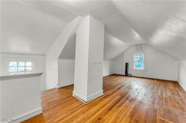 additional living space featuring light hardwood / wood-style flooring and vaulted ceiling