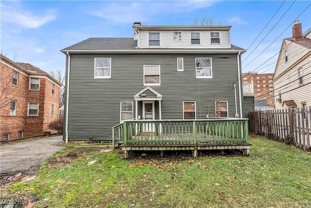 rear view of property with a deck and a lawn