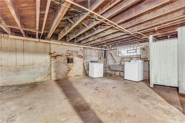 basement with electric panel, sink, and washer and dryer