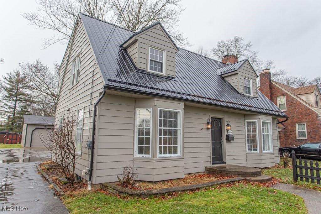 cape cod home with a garage and an outdoor structure