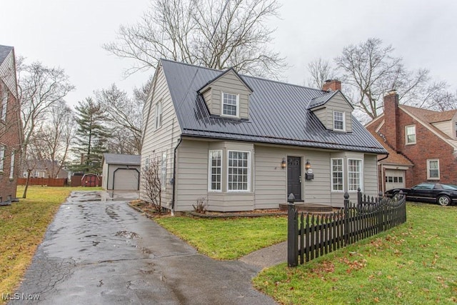 cape cod house with an outbuilding, a garage, and a front yard