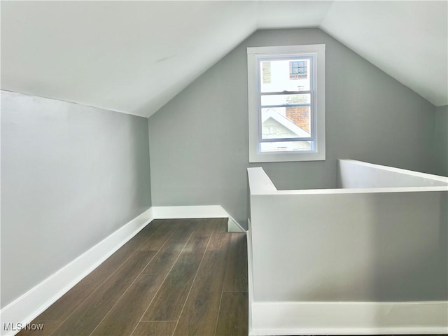 additional living space with dark hardwood / wood-style flooring and vaulted ceiling