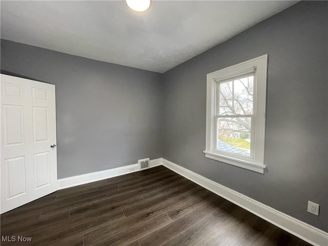 spare room with dark wood-type flooring