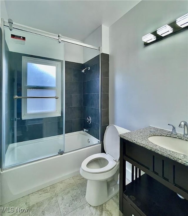 full bathroom with vanity, bath / shower combo with glass door, and toilet