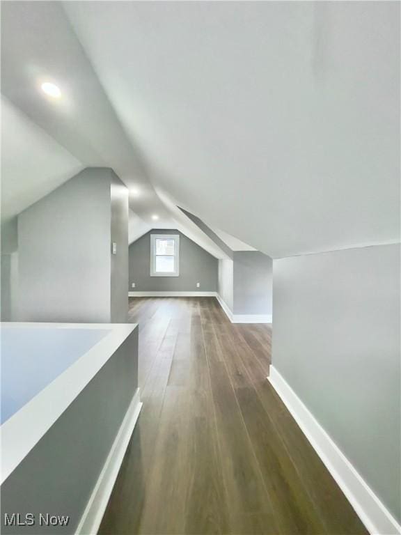 additional living space with dark hardwood / wood-style floors and vaulted ceiling