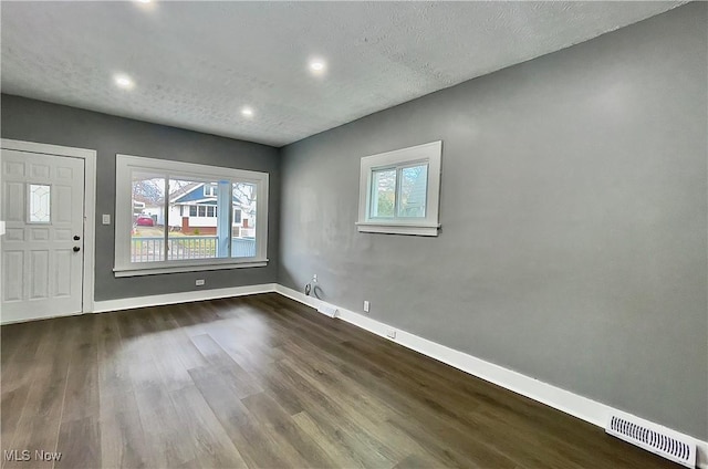 entryway with a textured ceiling and dark hardwood / wood-style floors