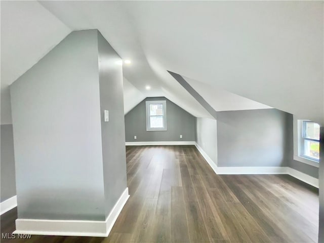 bonus room with dark hardwood / wood-style floors and lofted ceiling