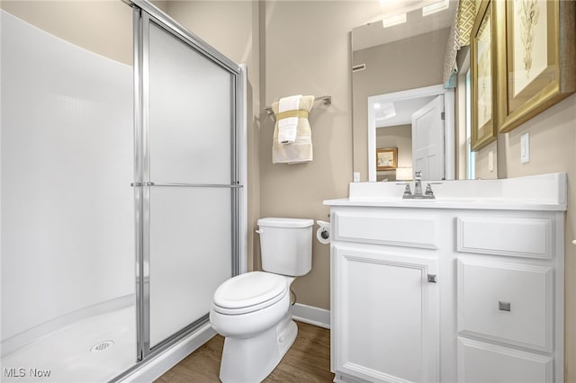 bathroom featuring vanity, hardwood / wood-style flooring, toilet, and a shower with shower door