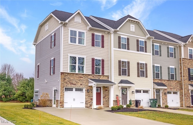 townhome / multi-family property featuring a front yard and a garage